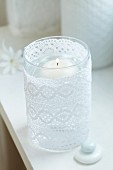 Floating candle in lantern wrapped in lace ribbon