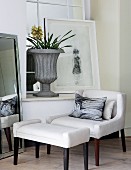 Art-deco-style armchair and footstool below window with picture & urn-shaped planter on windowsill