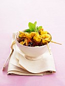 Chicken skewers and sweet and sour vegetables with saffron threads
