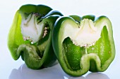 Fresh green pepper sliced into 2 halves showing seeds