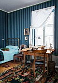 Gestreifte Wandgestaltung in Blautönen, dazu der Biedermeier-Schreibtisch vor dem Fenster für ein individuelles Gästezimmer