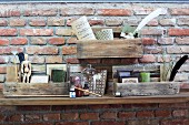 Collection of objet on small shelves made from pallet remnants mounted on brick wall