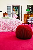 Pouf aus Merinowolle auf pinkfarbenem Teppich in Schlafzimmer
