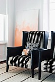Elegant armchairs upholstered in black leather and geometric, black and white patterned fabric