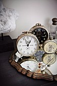 Collection of vintage clocks on mirror with carved frame
