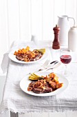 Fried beef steak with fried onions, arranged on two plates