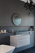 Ornate mirror and modern washstand on anthracite wall with long, narrow niche