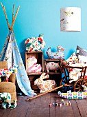 Bright, patterned fabrics in child's bedroom made into stylised animal-shaped cushions, lampshade and indoor teepee
