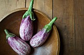 Striped aubergines in a wooden bowl