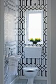 Guest lavatory with black and white graphic pattern on tiles