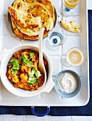 Cauliflower curry with tomatoes and coriander leaves, with naan bread