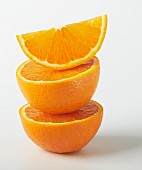 A stack of orange halves and a wedge of orange