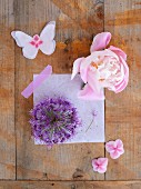 Flowers and paper butterfly on wooden surface