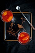 Orange and Campari jelly in a glass glass on the tray