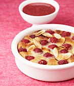 Baked dessert with strawberries and almonds, served with cherry sauce