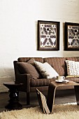 Braun gestreiftes Sofa mit Beistelltischen und selbstgebastelte Wandlampen in Bilderrahmen