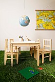 Hand-crafted globe lampshade above children's table on artificial grass carpet