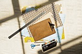 Sheets of variously patterned paper, clipboards, metal ruler, scissors and spray can