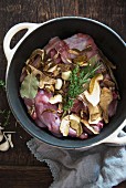 Rabbit, mushrooms, garlic and herbs in a casserole dish
