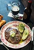 Beef steak with herb butter, potatoes and beer