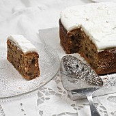 Partly sliced fruit cake with icing