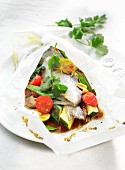 Trout in parchment paper with courgette, tomatoes and peanuts