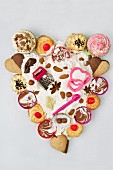 Cupcakes, biscuits, baking paraphernalia, chocolate and flour, arranged in a heart shape