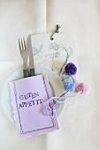 Table decoration: cutlery in hand-made, stitched paper bag with stencilled letters and pompoms