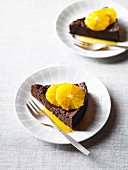 Two slices of chocolate torte with oranges