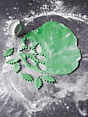 Holly leaves cut out of icing as decoration for Christmas baking