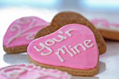Small gingerbread hearts decorated with pink glacé icing