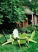 Grüe Gartenstühle auf der Wiese vor Wochenendhaus in ländlicher Umgebung