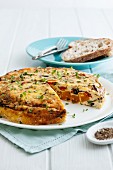 Roasted vegetable and olive frittata, one slice removed