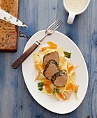 Veal fillet with a herb crust on ribbon pasta and carrot strips