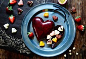 Heart-shaped chocolates with a heart-shaped chocolate box and strawberries