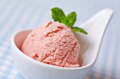 A scoop of home-made raspberry ice cream with mint leaves