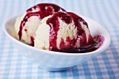 Two fresh scoops of ice cream with home-made blueberry sauce
