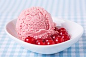 A scoop of home-made redcurrant ice cream with redcurrants