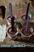 Four chocolate shooters, chocolate ice cream on sticks in shot glasses