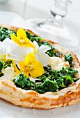A spinach tart with edible flowers
