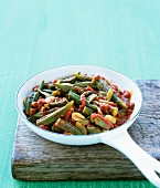A dish of okra and tomatoes in a pan
