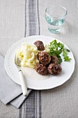 Meatballs with a pale sauce and mashed potato