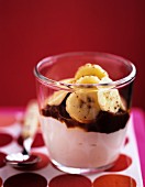 A yoghurt dessert with chocolate sauce and bananas