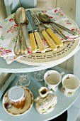 Vintage atmosphere; nostalgic cutlery and English crockery on light blue corner shelves