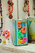 Magnetic letters reading SOAP stuck on old, vintage, metal tea caddy printed with Chinese characters in bathroom
