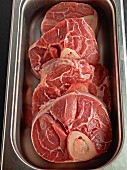 Raw pork chops in a metal container