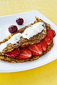 Crepe with strawberries, cherries and cream topping