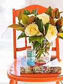 Magnificent bouquet of roses in a glass vase on a vintage chair