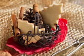 A wire basket of Christmas biscuits, pine cones and cinnamon sticks