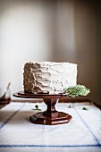 Rosemary Corn Cake with Brown Butter and Honey Buttercream Frosting on a wooden cake plate